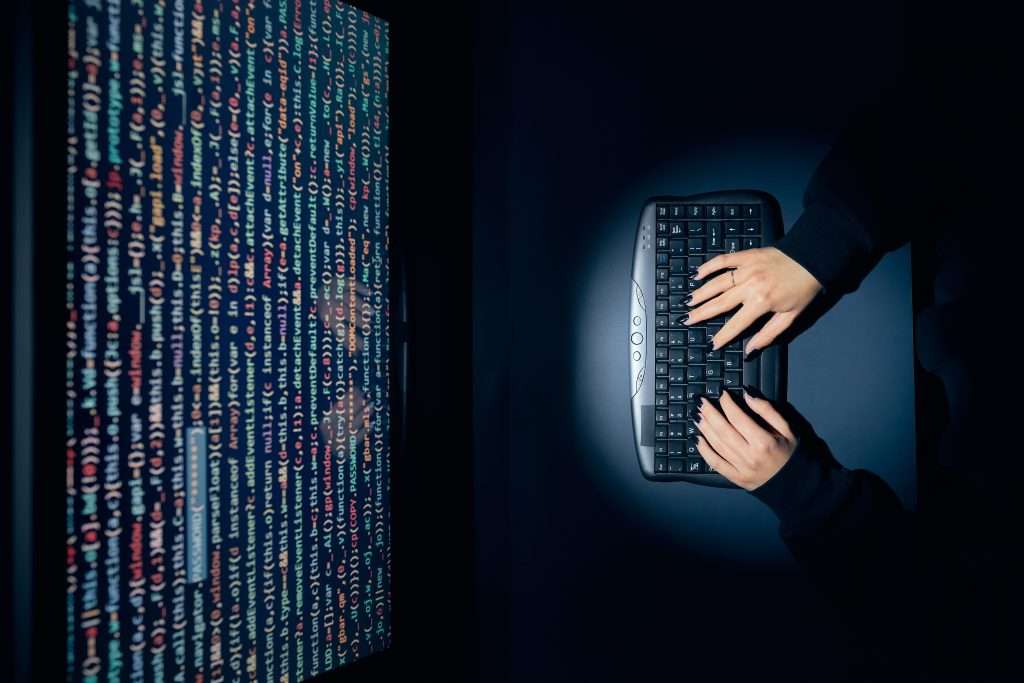 Cyber security threat. Young woman using computer to break protection. Network security threat